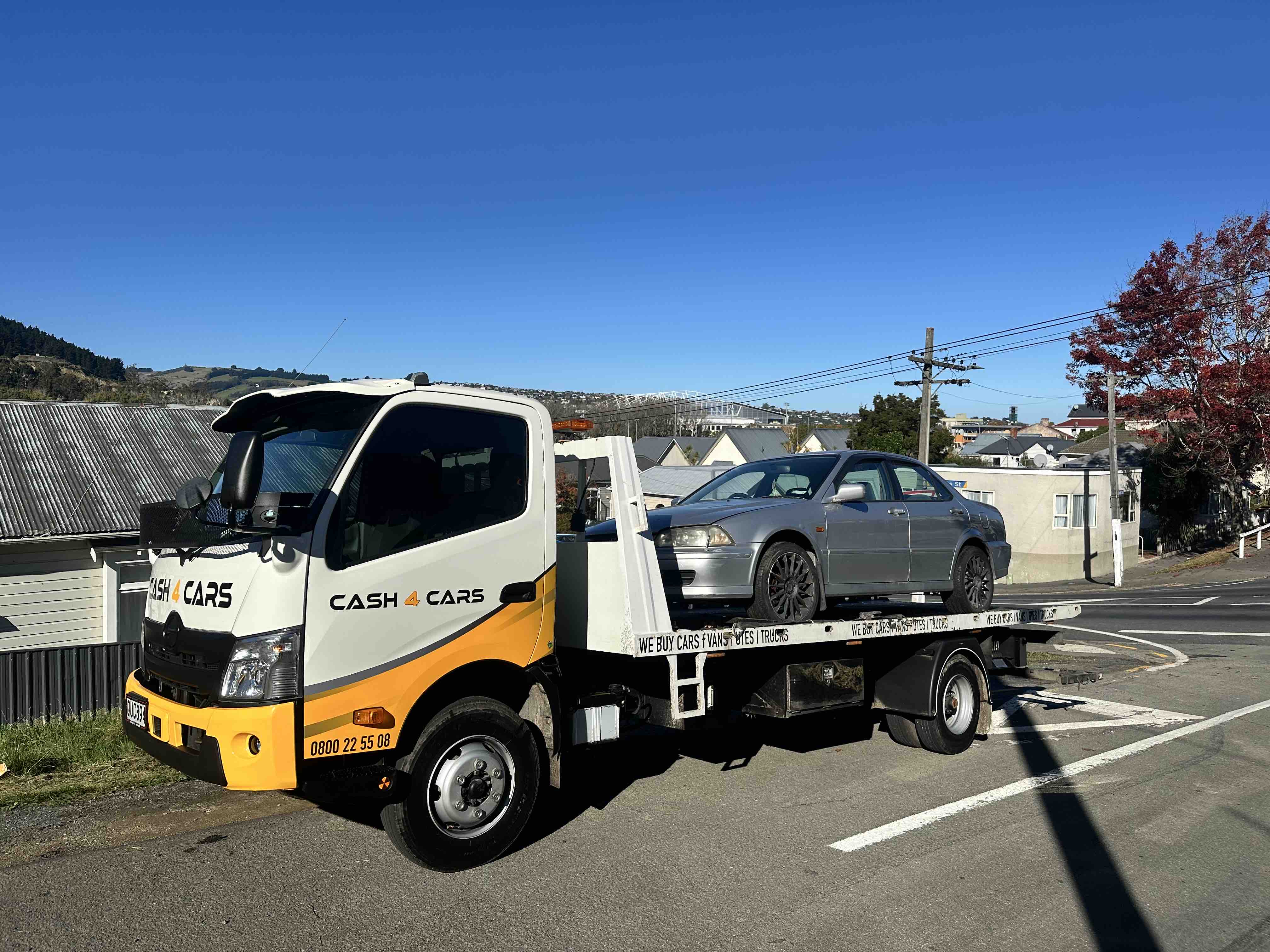 Cash 4 Cars removal truck carrying a grey sedan